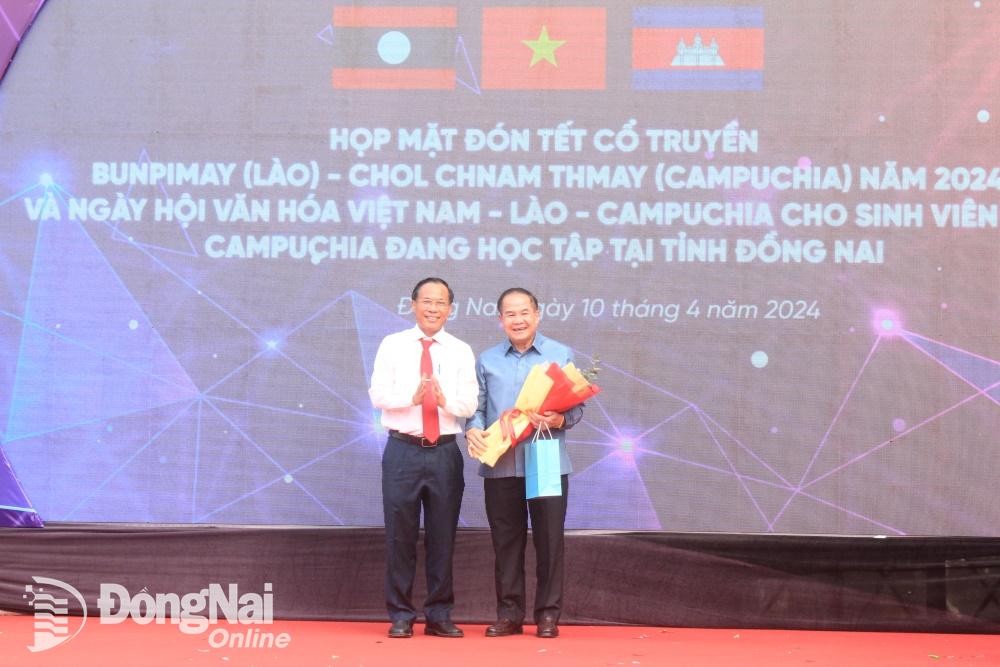 Trưởng ban Tuyên giáo Tỉnh ủy Phạm Xuân Hòa tặng hoa Phó Tổng lãnh sự nước Cộng hòa dân chủ nhân dân Lào tại Thành phố Hồ Chí Minh Amphay Souvannaseng sau khi phát biểu tại chương trình. Ảnh: Nga Sơn