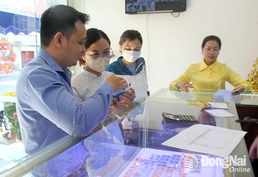 Khách hàng tham khảo các loại vàng miếng tại một trung tâm kim hoàn ở thành phố Biên Hòa. Ảnh: Hải Hà