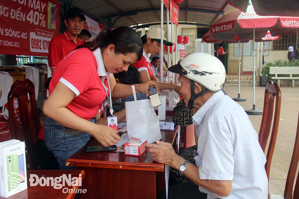 Nhân viên của Viettel Đồng Nai hỗ trợ, tư vấn người dân ở xã Sông Trầu (huyện Trảng Bom) chuyển đổi từ sử dụng điện thoại 2G sang sử dụng điện thoại kết nối 4G. Ảnh: Hải Quân