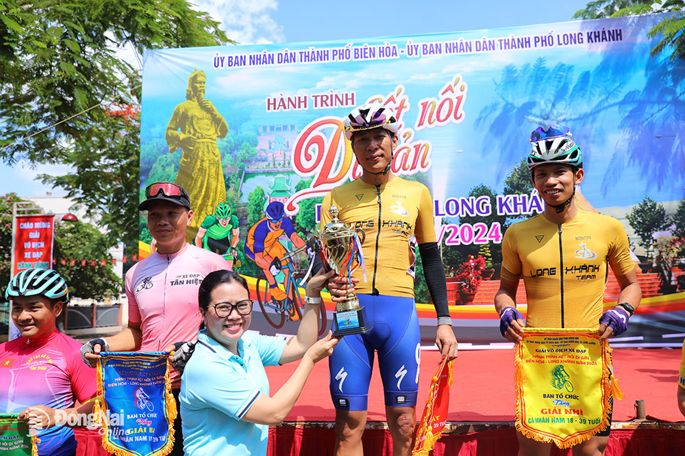 Giám đốc Sở Văn hóa, thể thao và du lịch Lê Thị Ngọc Loan trao cúp cho vận động viên Lê Đình Thương của câu lạc bộ xe đạp thành phố Long Khánh 1, vô địch nhóm 18-39 tuổi. Ảnh: Huy Anh