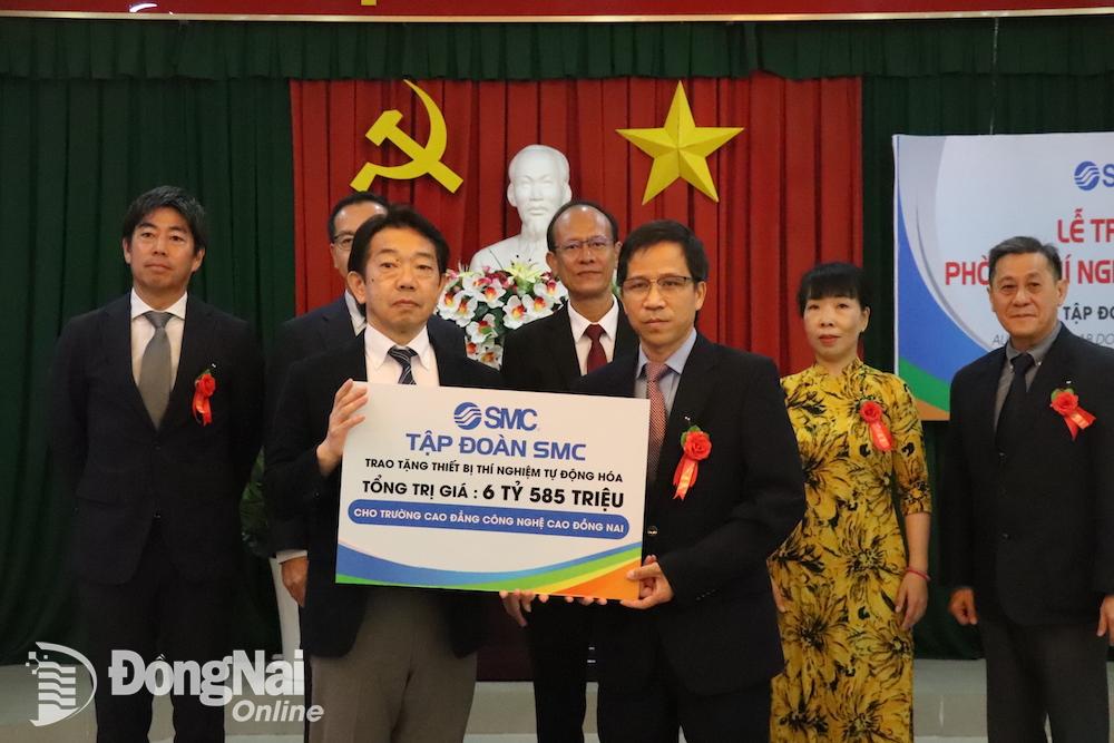Đại diện Công ty TNHH SMC Corporation (Việt Nam) trao biểu trưng tặng phòng thực hành SMC Automation Lab cho Trường cao đẳng Công nghệ cao Đồng Nai. Ảnh: Hải Yến
