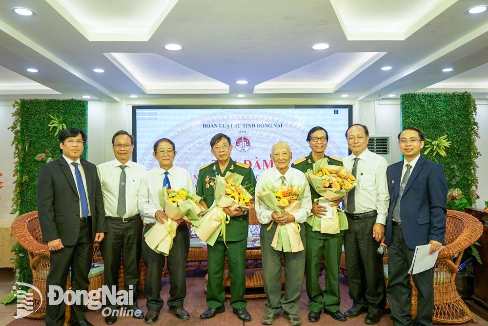 Ban chủ nhiệm Đoàn Luật sư tỉnh và các luật sư tham gia tọa đàm tặng hoa khách mời là nhân chứng lịch sử từng tham gia Chiến dịch Hồ Chí Minh. Ảnh: Lê Duy