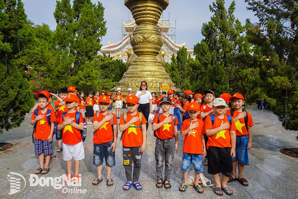 Các em thiếu nhi mặc áo cờ đỏ sao vàng tham quan tại Khu du lịch văn hóa Suối Tiên. Ảnh: S.T
