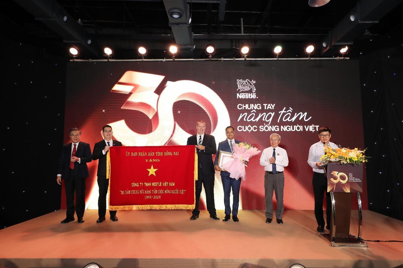 Đại diện tỉnh Đồng Nai trao tặng bức trướng “30 năm chung sức nâng tầm cuộc sống người Việt” cho Nestlé Việt Nam. Ảnh: Thành Luân