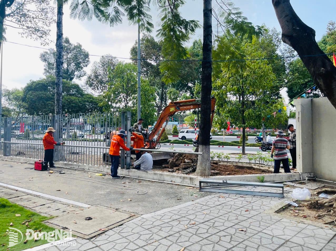 Các đơn vị thi công đang tháo gỡ hàng rào phía trước Trung tâm Sự kiện và đối ngoại tỉnh. Ảnh: Công Nghĩa