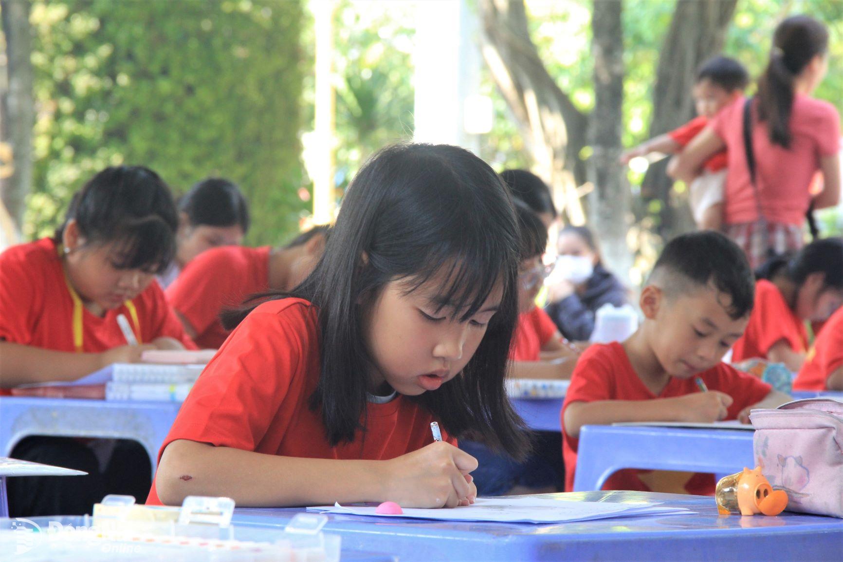 Các em thiếu nhi mặc áo cờ đỏ sao vàng tham gia vẽ tranh với chủ đề Non sông thống nhất. Ảnh: Nga Sơn

