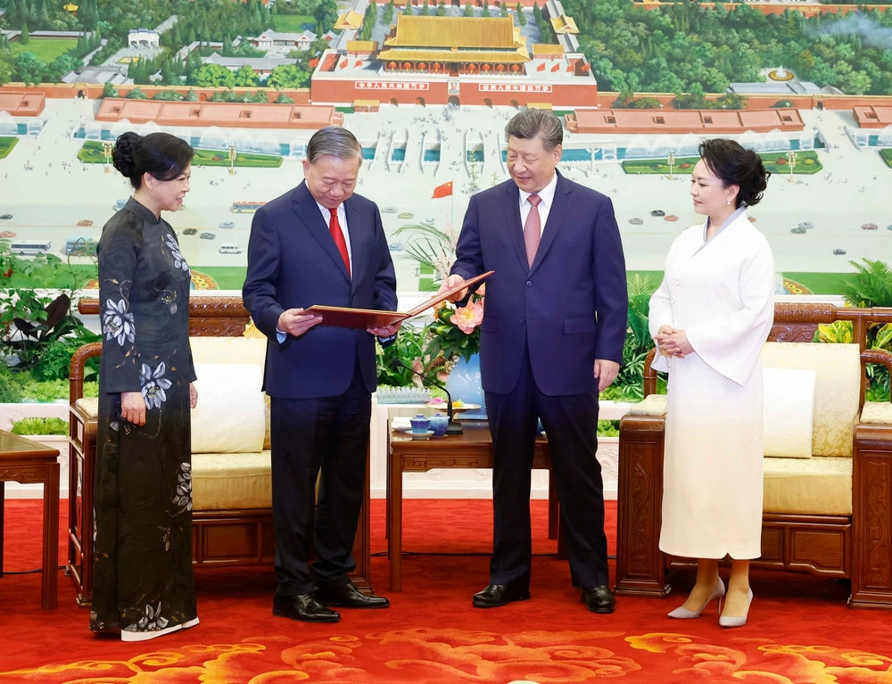 Tổng Bí thư, Chủ tịch nước Trung Quốc Tập Cận Bình và Phu nhân tặng album ảnh cho Tổng Bí thư, Chủ tịch nước Tô Lâm và Phu nhân. (Ảnh: TTXVN)
