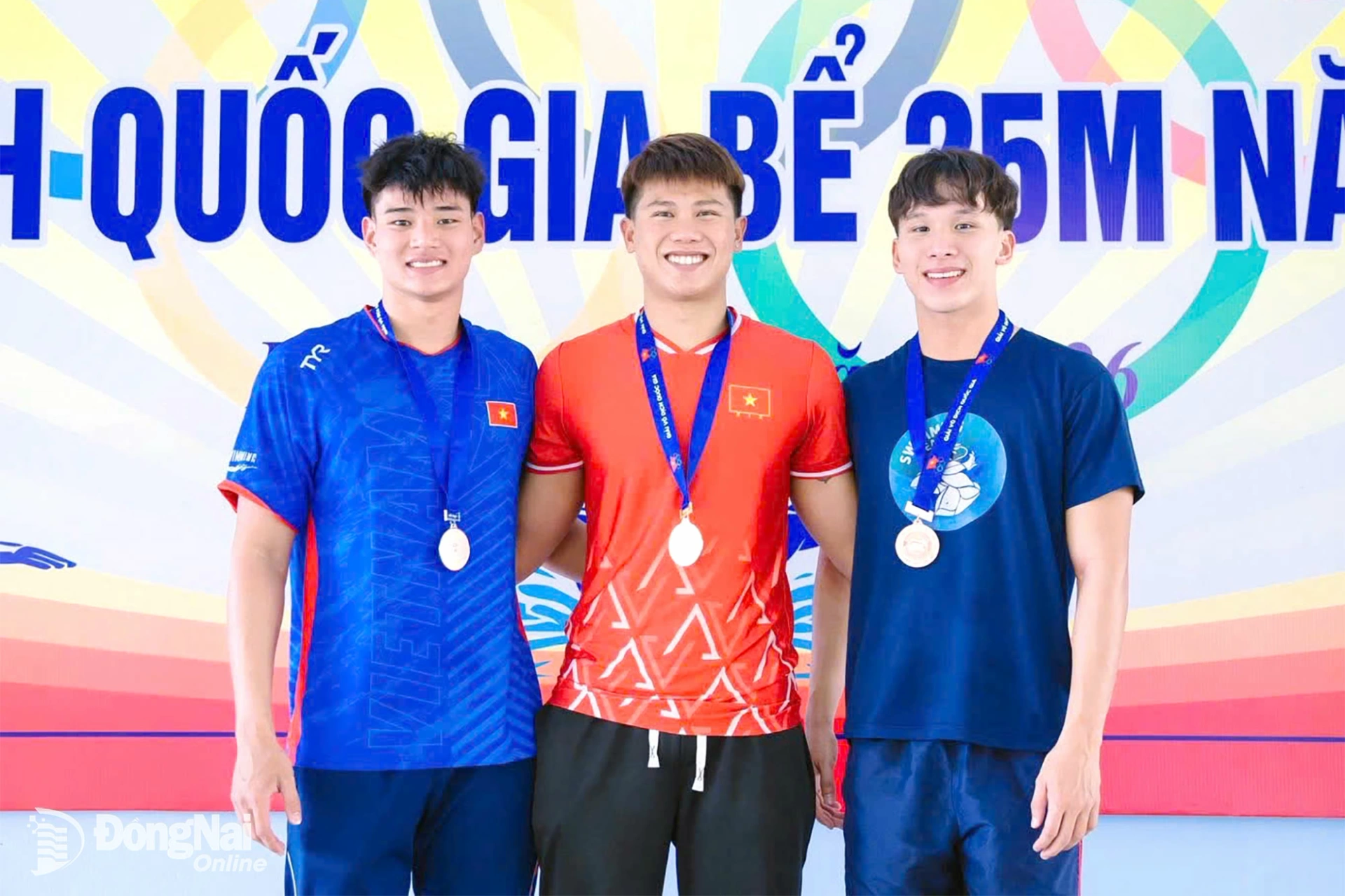 Kình ngư Vũ Đặng Nhật Nam (Đồng Nai, áo đỏ) cùng đồng đội Nguyễn Lê Truyền Đạt (bìa trái) trên bục nhận huy chương nội dung 400m chân vịt đôi nam Giải lặn vô địch quốc gia 2026. Ảnh: ĐVCC