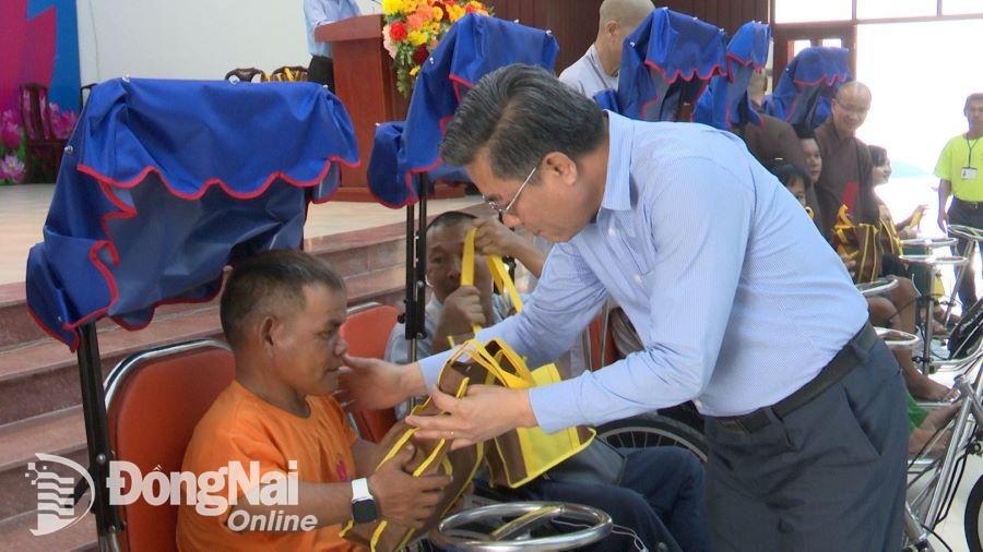 Bí thư Huyện ủy Long Thành Dương Minh Dũng trao tặng quà và xe lăn, xe lắc cho hội viên CLB Người khuyết tật huyện. Ảnh: Nam Anh