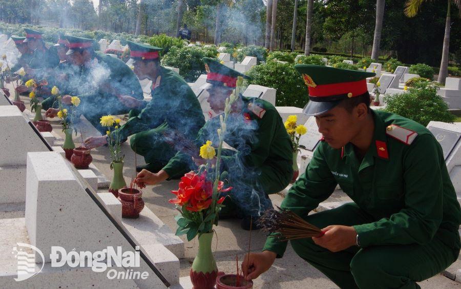 Cán bộ chiến sĩ thắp hương mộ phần hùng liệt sĩ tại Nghĩa trang liệt sĩ tỉnh. Ảnh: Nguyệt Hà