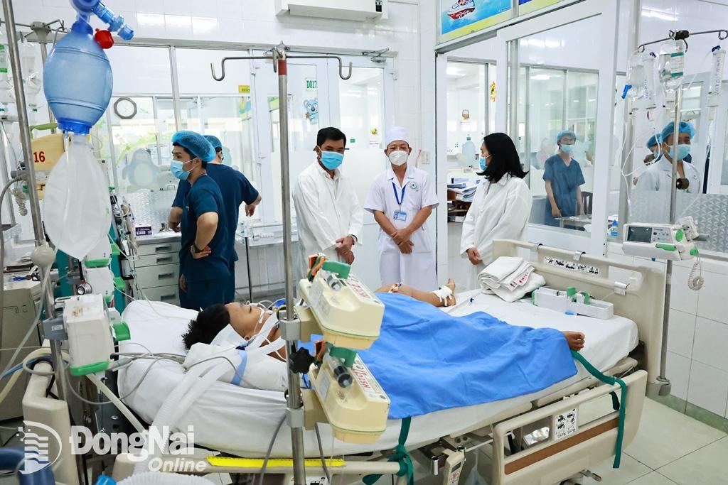 Lãnh đạo thành phố Long Khánh thăm một bệnh nhi đang được điều trị tích cực tại Bệnh viện nhi đồng Đồng Nai. Ảnh: Công Nghĩa