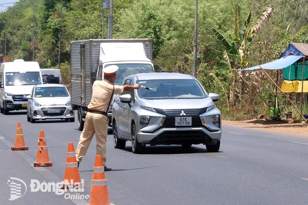 Lực lượng Cảnh sát giao thông kiểm soát các phương tiện lưu thông trên quốc lộ 20 (huyện Định Quán). Ảnh: Minh Thành