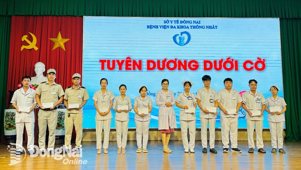 Phó giám đốc Bệnh viện Đa khoa Thống Nhất Nguyễn Thị Kim Loan khen thưởng các điều dưỡng, hộ lý, bảo vệ. Ảnh: H.Dung