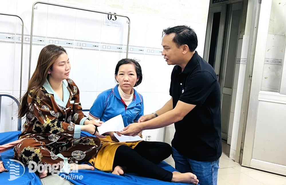 Đại diện lãnh đạo Công ty TNHH De Chang Việt Nam thăm hỏi công nhân bị ngộ độc thực phẩm. Ảnh: CTV