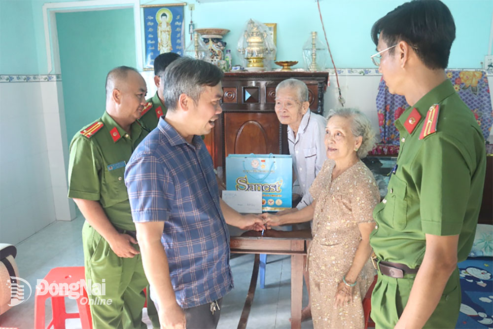 Lãnh đạo Phòng Cảnh sát cơ động Công an tỉnh tặng quà cho người già neo đơn tại huyện Định Quán. Ảnh: ĐVCC