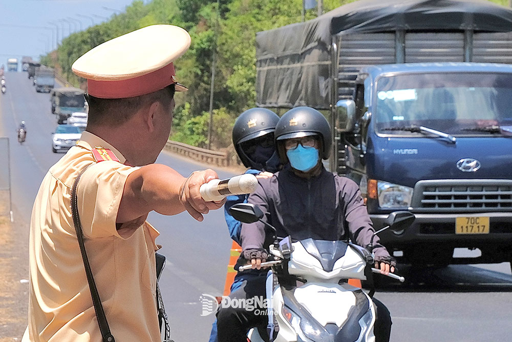 Lực lượng cảnh sát giao thông kiểm soát người điều khiển xe máy trên quốc lộ 20 (huyện Định Quán). Ảnh: Đ.Tùng
