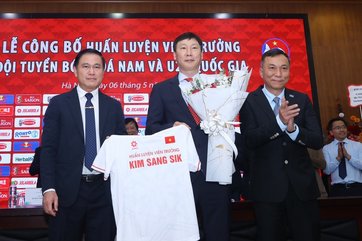 Huấn luyện viên Kim Sang Sik (giữa) nhận áo đấu và hoa chúc mừng từ Chủ tịch VFF Trần Quốc Tuấn (bìa phải) và Phó chủ tịch VFF Trần Anh Tú. Ảnh: VFF