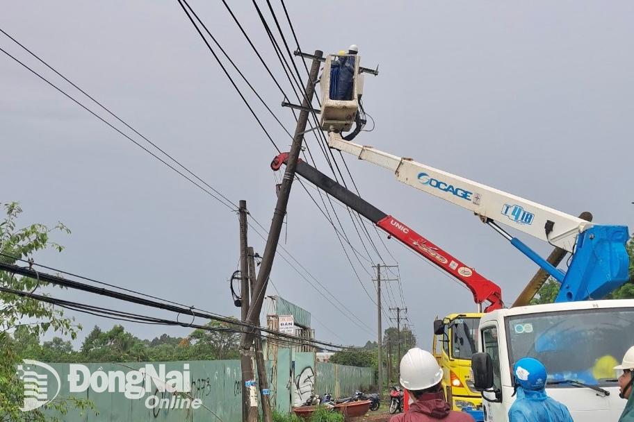 Điện lực Thống Nhất đang khắc phục sự cố xe tải tông gãy cột điện trên quốc lộ 20. Ảnh: CTV