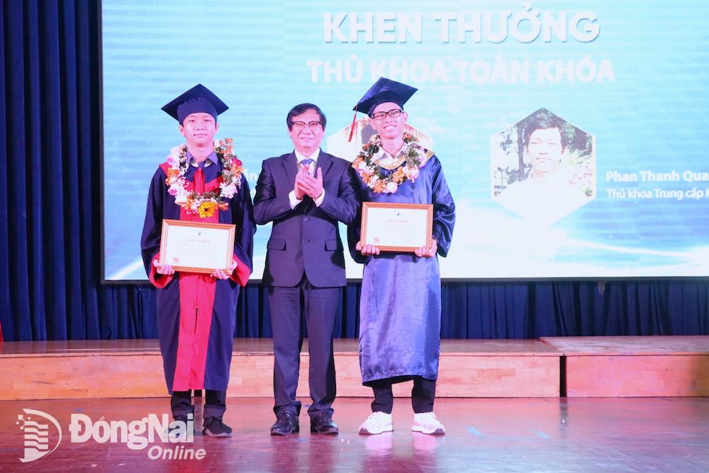 Phó chủ tịch UBND tỉnh Nguyễn Sơn Hùng trao khen cho 2 sinh viên tốt nghiệp thủ khoa toàn khoá. Ảnh: HẢI YẾN