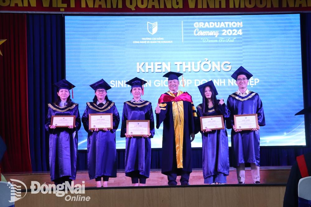 Hiệu trưởng Trường cao đẳng Công nghệ và quản trị Sonadezi Nguyễn Tiến Mạnh trao khen thưởng cho các sinh viên tốt nghiệp của lớp doanh nghiệp. Ảnh: HẢI YẾN