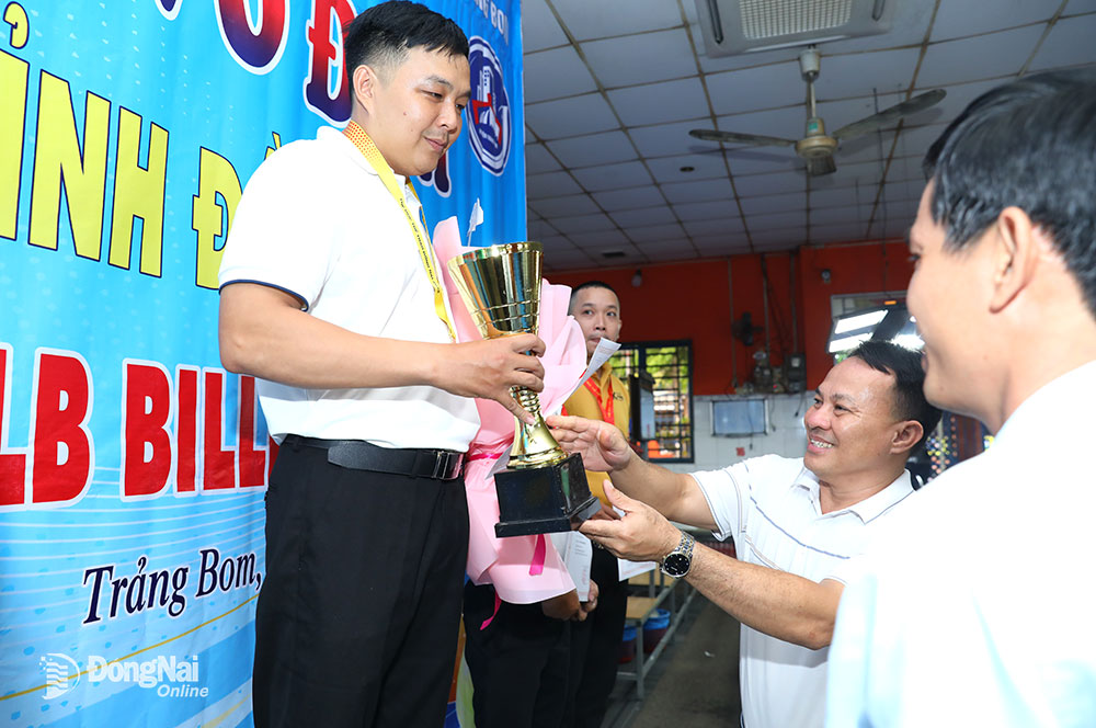 Giám đốc Trung tâm Huấn luyện và thi đấu thể dục thể thao tỉnh Bùi Anh Vũ trao cúp vô địch cho cơ thủ Nguyễn Hồng Thanh. Ảnh: Huy Anh