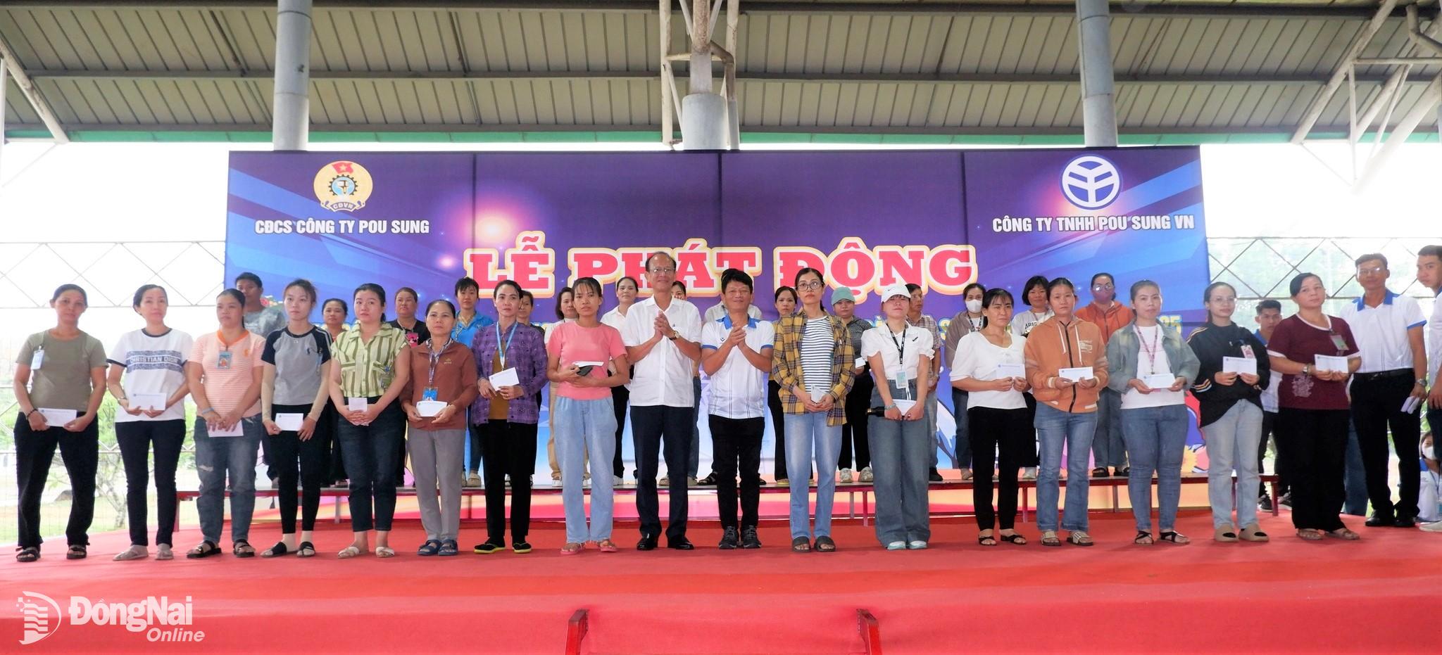 2-	Đại diện Sở Nội vụ và lãnh đạo Công ty TNHH Pou Sung Việt Nam trao quà công nhân khó khăn. Ảnh: N.Hòa