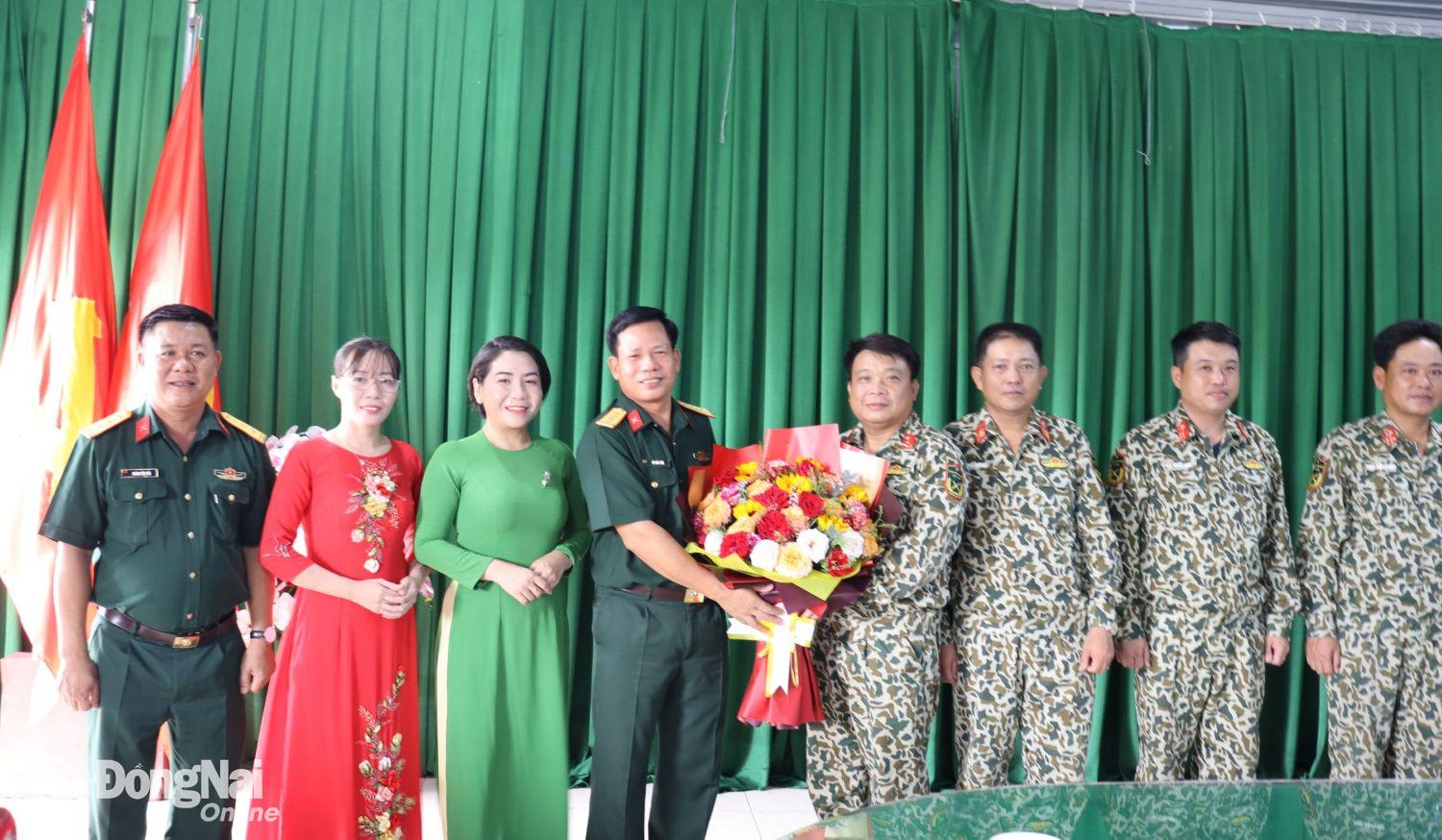 Chính ủy Sư đoàn 309 tặng hoa chúc mừng đoàn A50 Binh chủng Đặc công hoàn thành xuất sắc nhiệm vụ. Ảnh: Nguyệt Hà