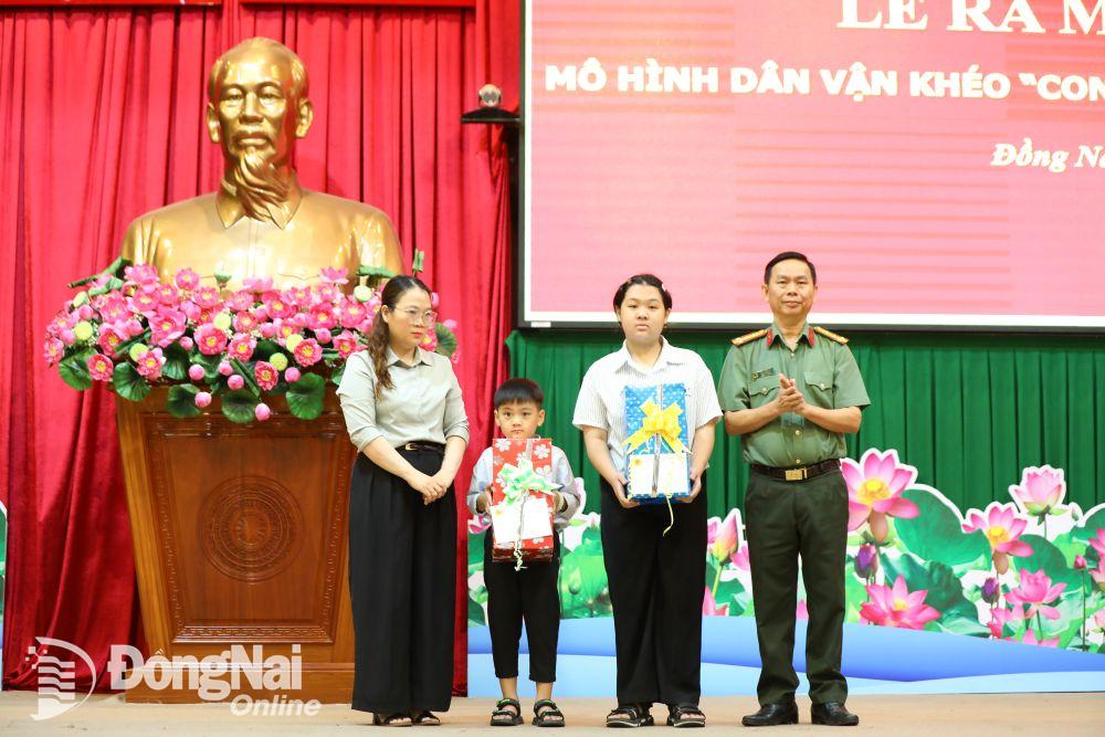 Công an tỉnh trao bảng biểu trưng và quà cho hai người con của anh Huỳnh Trí Phúc. Ảnh: Tố Tâm