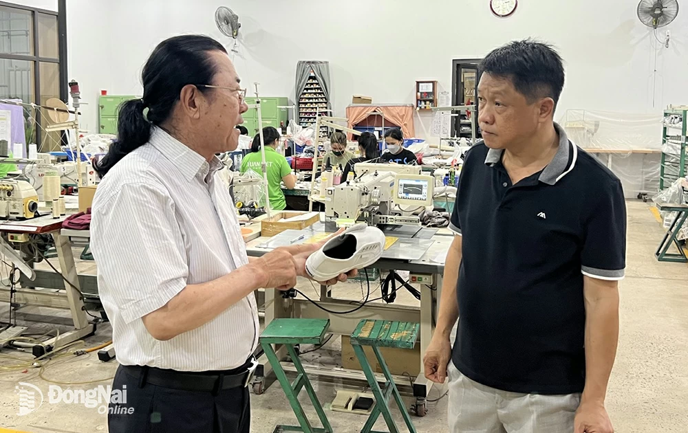 Ông Tắc trao đổi với đồng nghiệp. Ảnh: Bích Nhàn