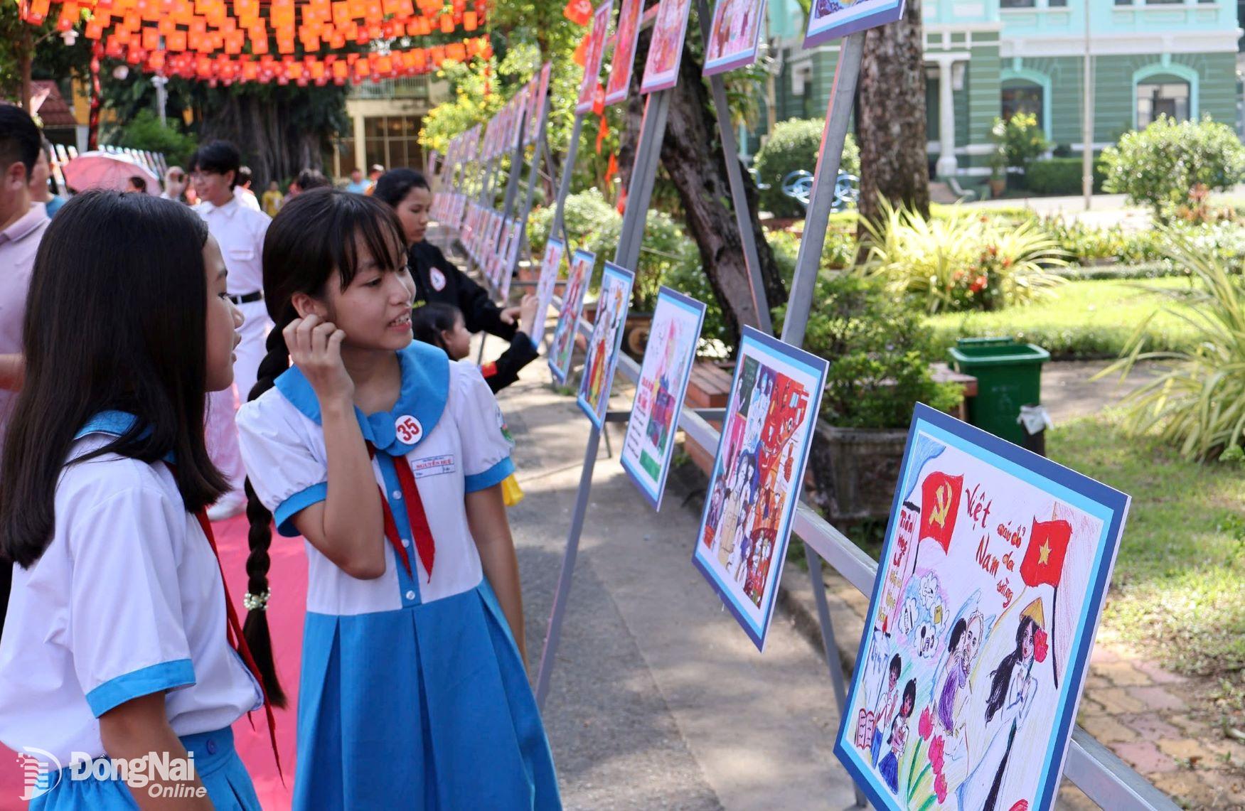 Các em thiếu nhi tham quan triển lãm tranh Bác Hồ với thiếu nhi – Thiếu nhi với Bác Hồ trong khuôn viên Nhà thiếu nhi Đồng Nai. Ảnh: ĐVCC