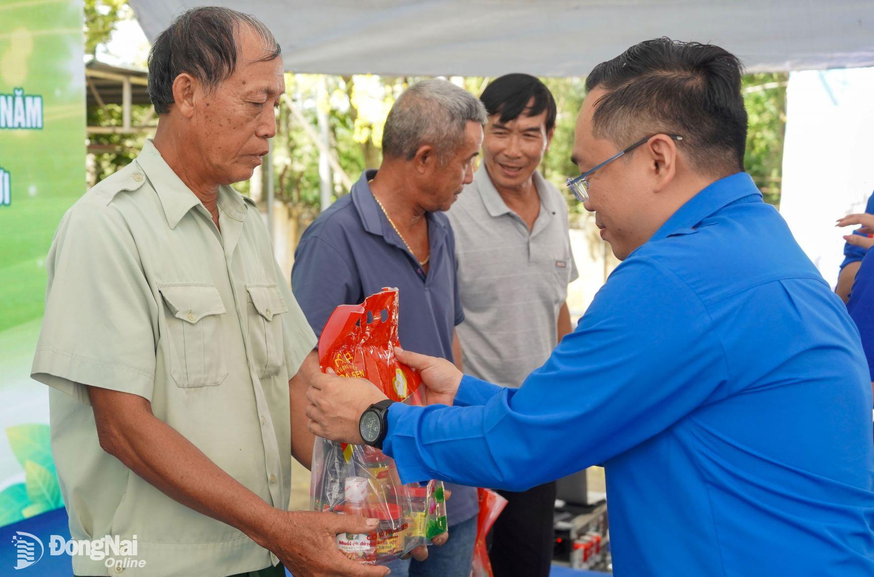 Bí thư Tỉnh đoàn Nguyễn Minh Kiên trao quà cho các hộ dân tại xã Lâm San (huyện Cẩm Mỹ). Ảnh: ĐVCC