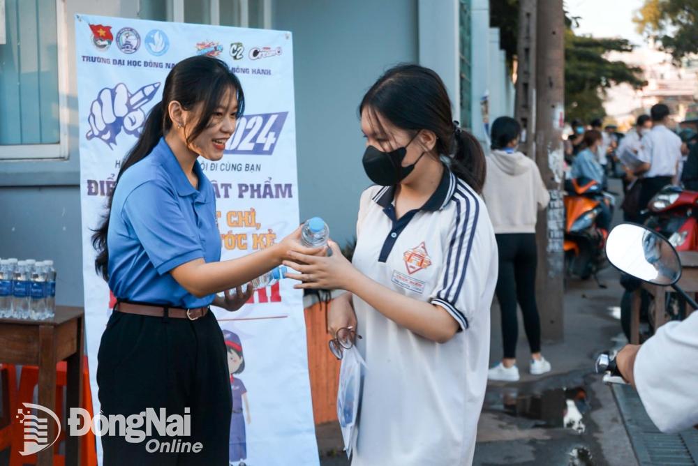 Đoàn thanh niên tặng nước uống cho các thí sinh trước điểm thi tại Trường trung học phổ thông Trấn Biên (phường Tam Hòa). Ảnh: Lê Duy
