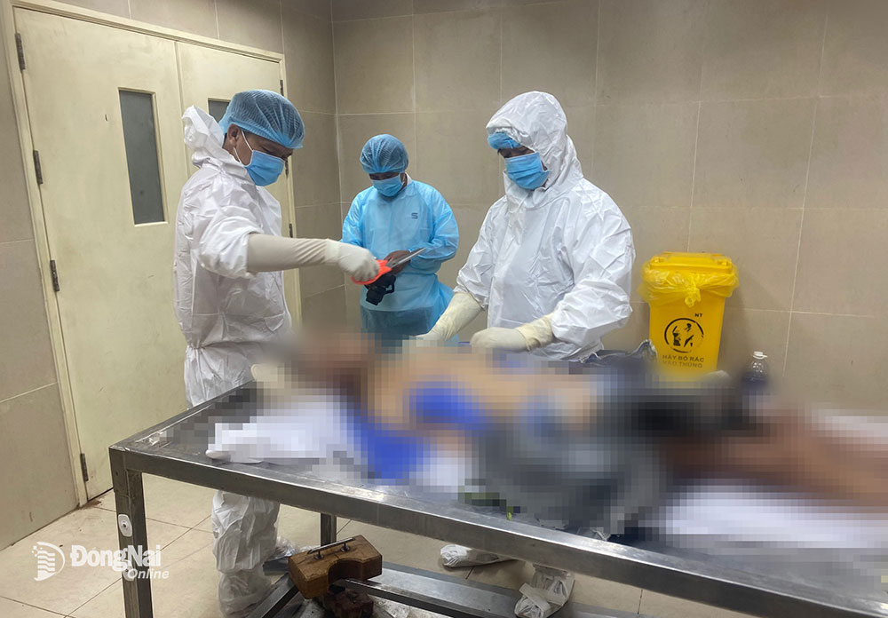 Các giám định viên của Trung tâm Pháp y Đồng Nai khám nghiệm tử thi theo quyết định trưng cầu của Công an huyện Tân Phú. Ảnh: T.T