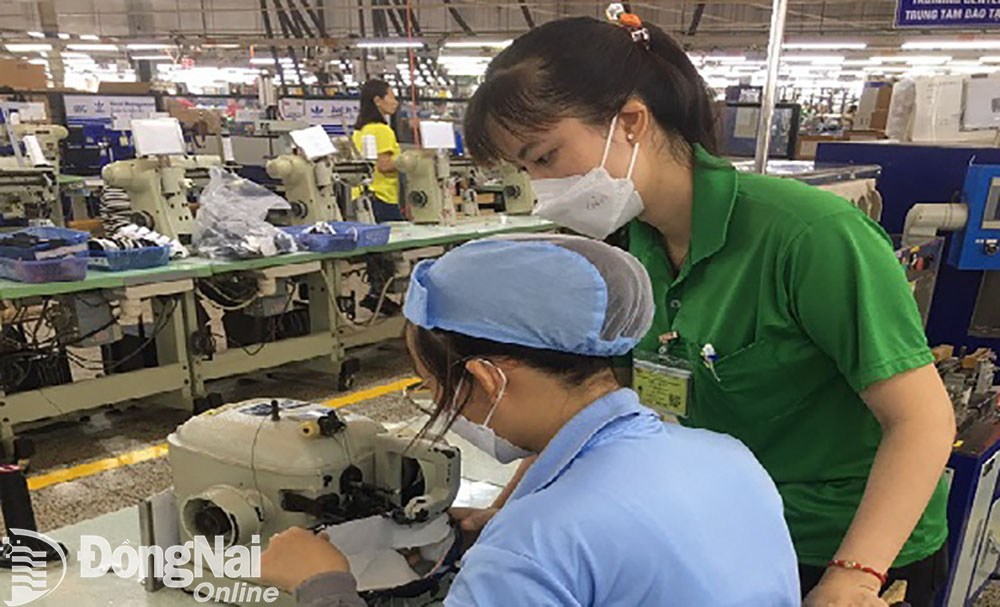 Chị Nguyễn Thị Dung hướng dẫn công nhân thực hiện các công đoạn làm ra sản phẩm. Ảnh: NVCC