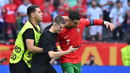 Một cổ động viên (áo đen) lao vào sân chụp ảnh với Ronaldo.