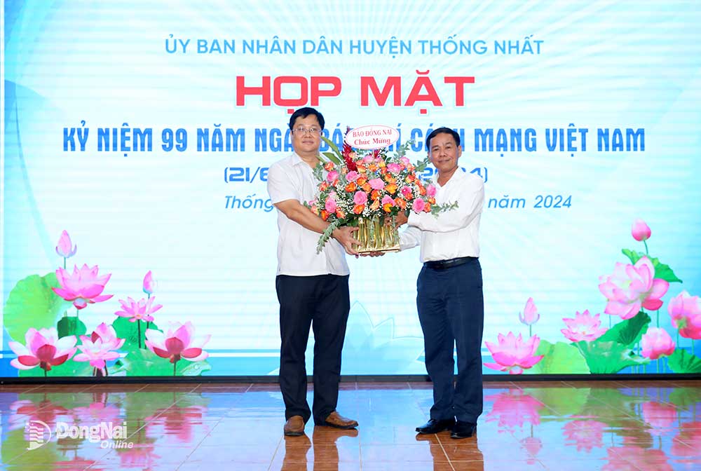 Phó tổng biên tập Báo Đồng Nai Đinh Kim Tuấn tặng hoa chúc mừng Trung tâm Văn hóa thông tin và thể thao huyện Thống Nhất tại buổi gặp mặt. Ảnh: Huy Anh