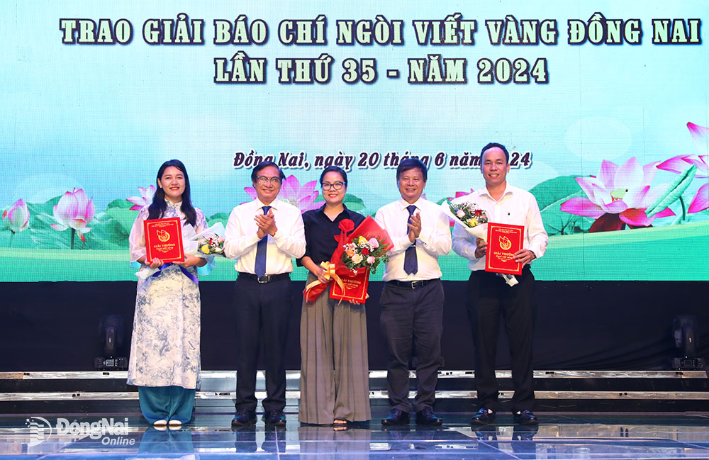 Phó chủ tịch UBND tỉnh Nguyễn Sơn Hùng (thứ 2 từ trái qua) và Phó chủ tịch Hội Nhà báo Việt Nam phụ trách phía Nam Trần Trọng Dũng trao giải cho tác giả, nhóm tác giả đạt giải Nhì giải báo chí Ngòi Viết Vàng Đồng Nai lần thứ 35. Ảnh Huy Anh