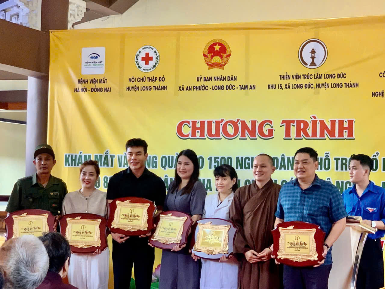 Lãnh đạo, bác sĩ Bệnh viện Mắt Hà Nội - Đồng Nai (2 người đứng giữa) nhận bảng vàng tri ân của địa phương trong chương trình khám mắt miễn phí, tặng quà cho người dân huyện Long Thành.