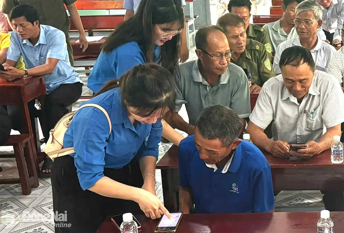 Đoàn thanh niên xã Phú Ngọc, huyện Định Quán hướng dẫn người dân sử dụng điện thoại thông minh. Ảnh: Hồng Loan