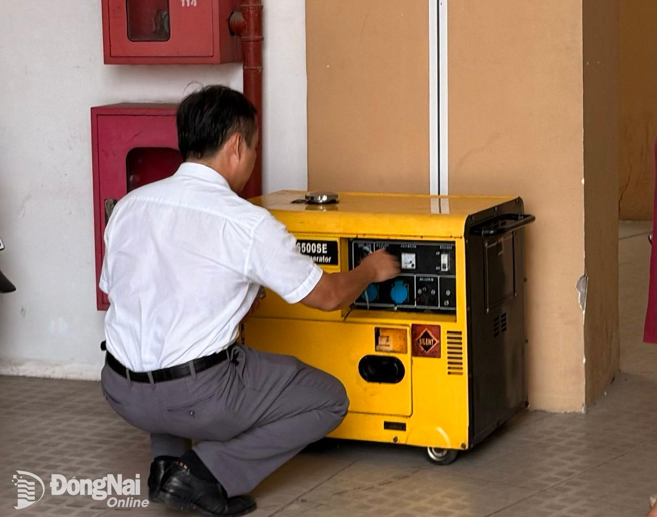 Cán bộ điểm thi tốt nghiệp tại Trường THPT Chu Văn An kiểm tra máy phát điện dự phòng phục vụ trong trường hợp xảy ra sự cố mất điện. Ảnh: Công Nghĩa 