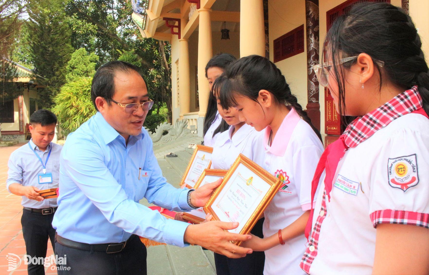 2-	Ông Trần Đăng Ninh, Chủ tịch Công đoàn cơ sở Tổng Công ty Công nghiệp thực phẩm Đồng Nai trao thưởng cho các em học sinh. Ảnh: Thảo My