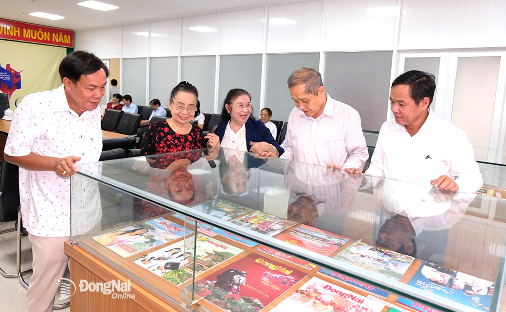 Nguyên lãnh đạo, phóng viên báo Đồng Nai xem những ấn phẩm trước đó của báo Đồng Nai. Ảnh: Đăng Tùng