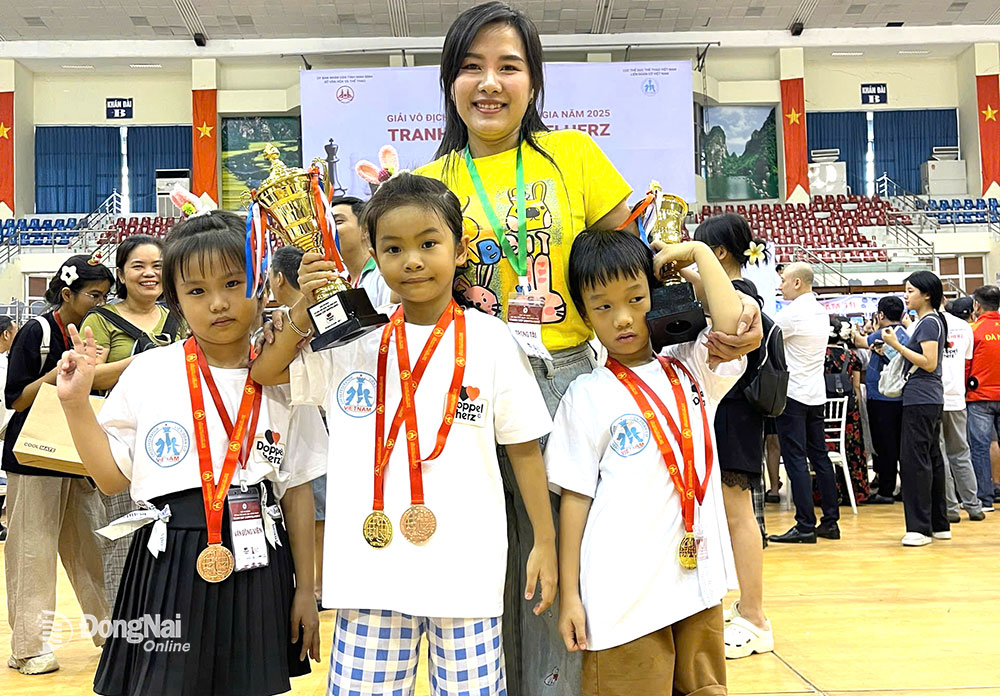 Huấn luyện viên Nguyễn Thùy Dương cùng với 3 kỳ thủ nhí Đồng Nai (từ trái qua là Nguyễn Phạm Bích Ngọc, Nguyễn Phạm Lam Thư và Lê Minh Quang) đạt huy chương nội dung cờ chớp. Ảnh: NVCC