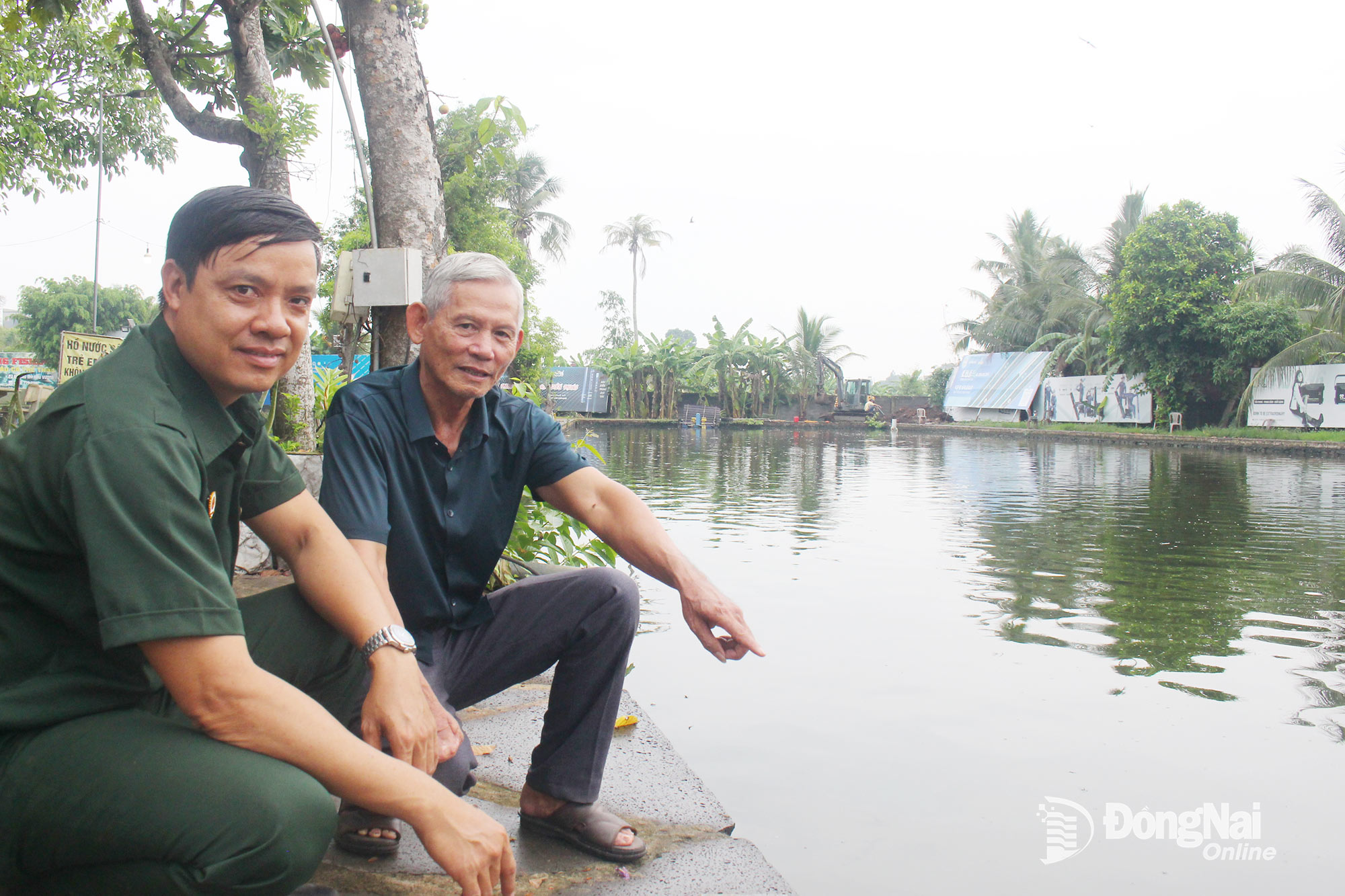 Thương binh 3/4 Đoàn Trung Ngọc (bên phải) giới thiệu về mô hình nuôi cá thương phẩm kết hợp với dịch vụ câu cá giải trí của mình.
