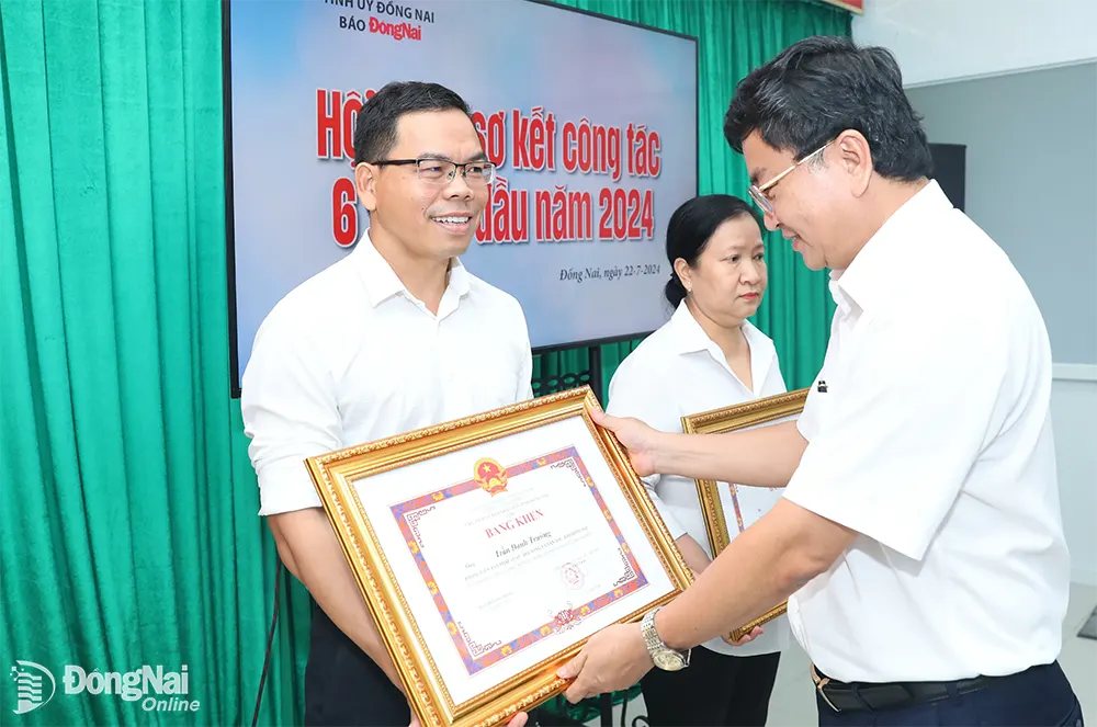 Tổng biên tập Báo Đồng Nai Đào Văn Tuấn trao bằng khen của UBND tỉnh cho 2 cá nhân có thành tích xuất sắc trong phong trào thi đua yêu nước. Ảnh: Huy Anh
