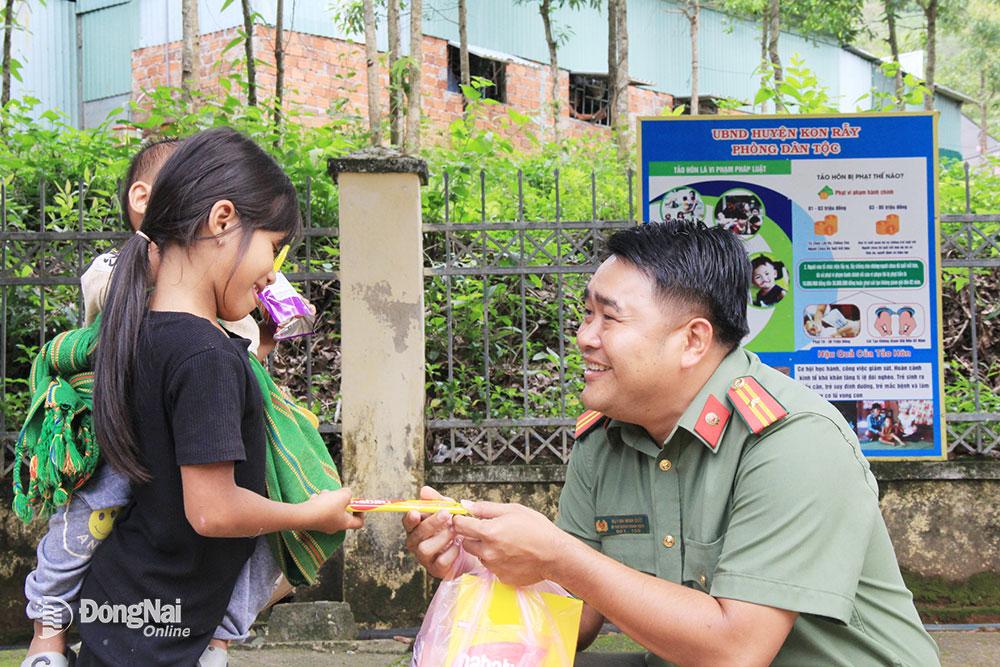 3. Thiếu tá Huỳnh Minh Đức, Trưởng ban thanh niên Công an tỉnh tặng quà cho trẻ em người dân tộc thiểu số ở xã Đăk Kôi, huyện Kon Rẫy (tỉnh Kon Tum).