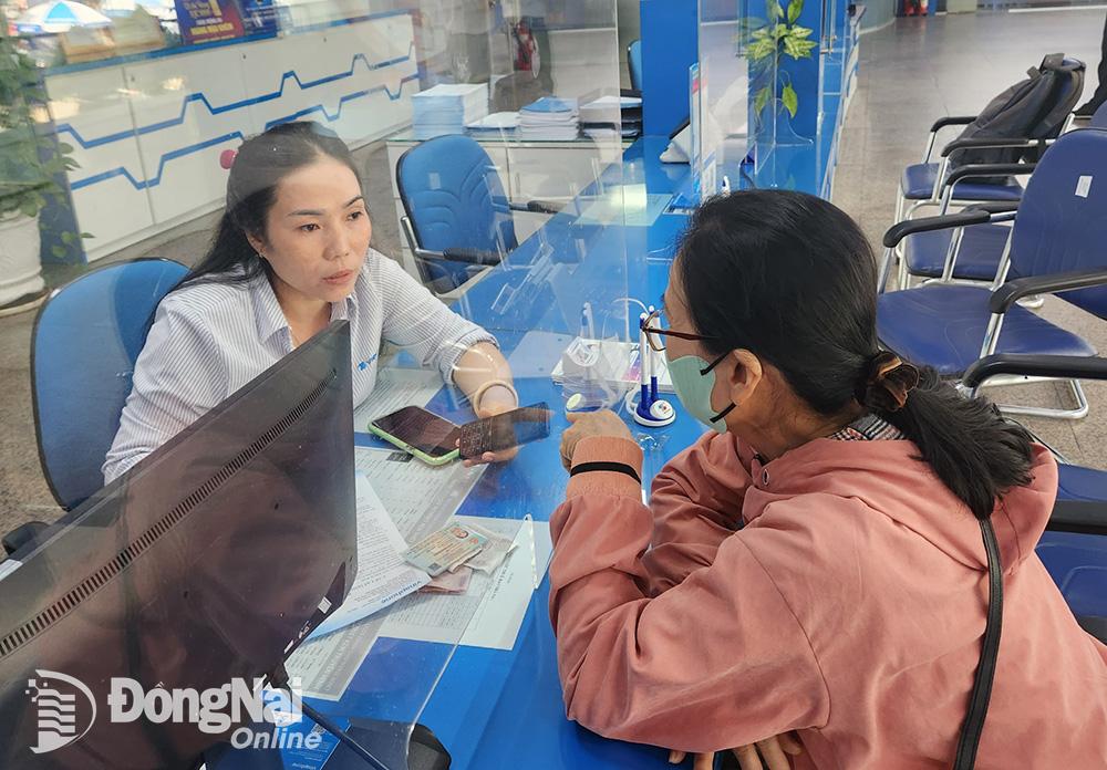 Nhân viên VNPT Đồng Nai hỗ trợ khách hàng chuyển đổi từ thiết bị di động sử dụng công nghệ 2G lên 4G. Ảnh: Hải Quân