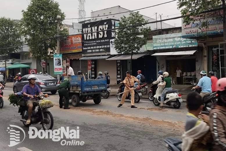 Đội Cảnh sát giao thông - trật tự Công an thành phố Biên Hòa dọn số đất bị xe tải ben làm đổ ra đường Phạm Văn Thuận (thành phố Biên Hòa). Ảnh: CTV