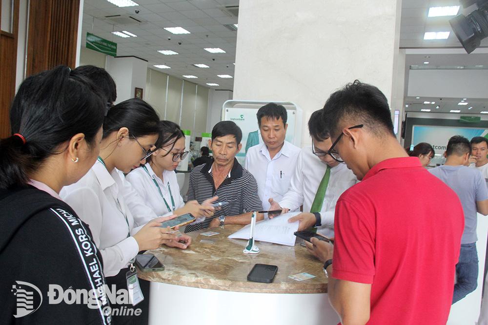 Khá đông khách hàng đến chi nhánh Vietcombank chi nhánh Đồng Nai để được hỗ trợ xác thực sinh trắc học vào sáng 1-7. Ảnh: Hải Quân