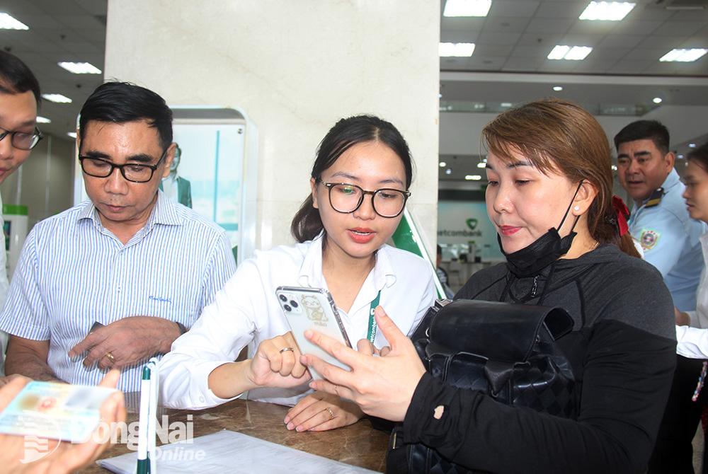 Vietcombank chi nhánh Đồng Nai tăng cường bố trí nhân sự hỗ trợ trực tiếp tại quầy giao dịch giúp khách hàng xác thực bằng sinh trắc học. Ảnh: Hải Quân